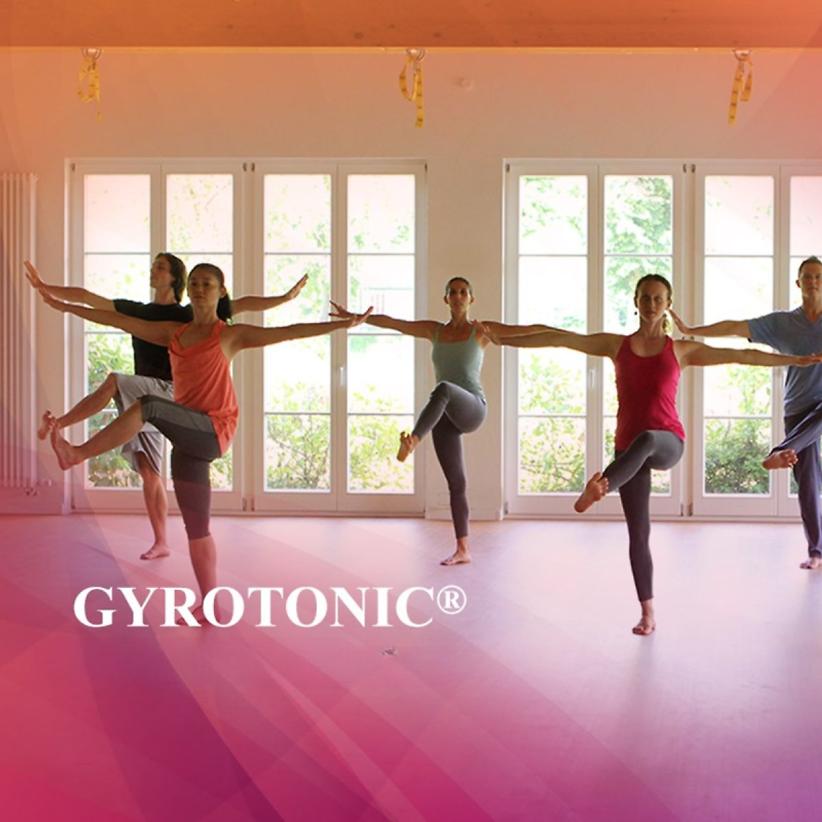 Una lezione di gruppo GYROTONIC® in equilibrio su una gamba, le braccia distese