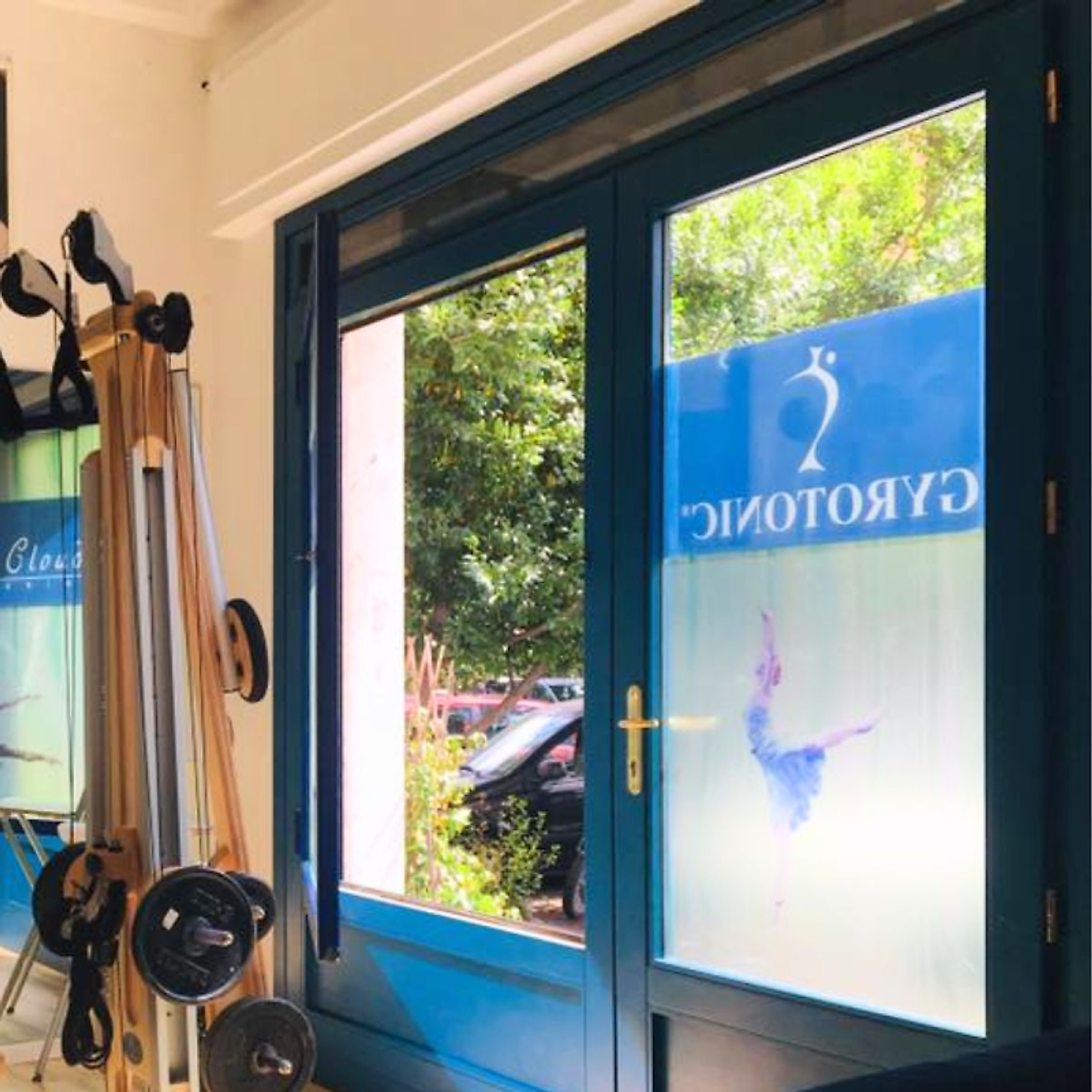 L'ingresso dello studio: la vetrata col marchio GYROTONIC® e gli attrezzi appesi a sinistra